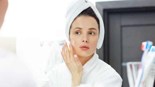 Woman applying moisturizer on her skin